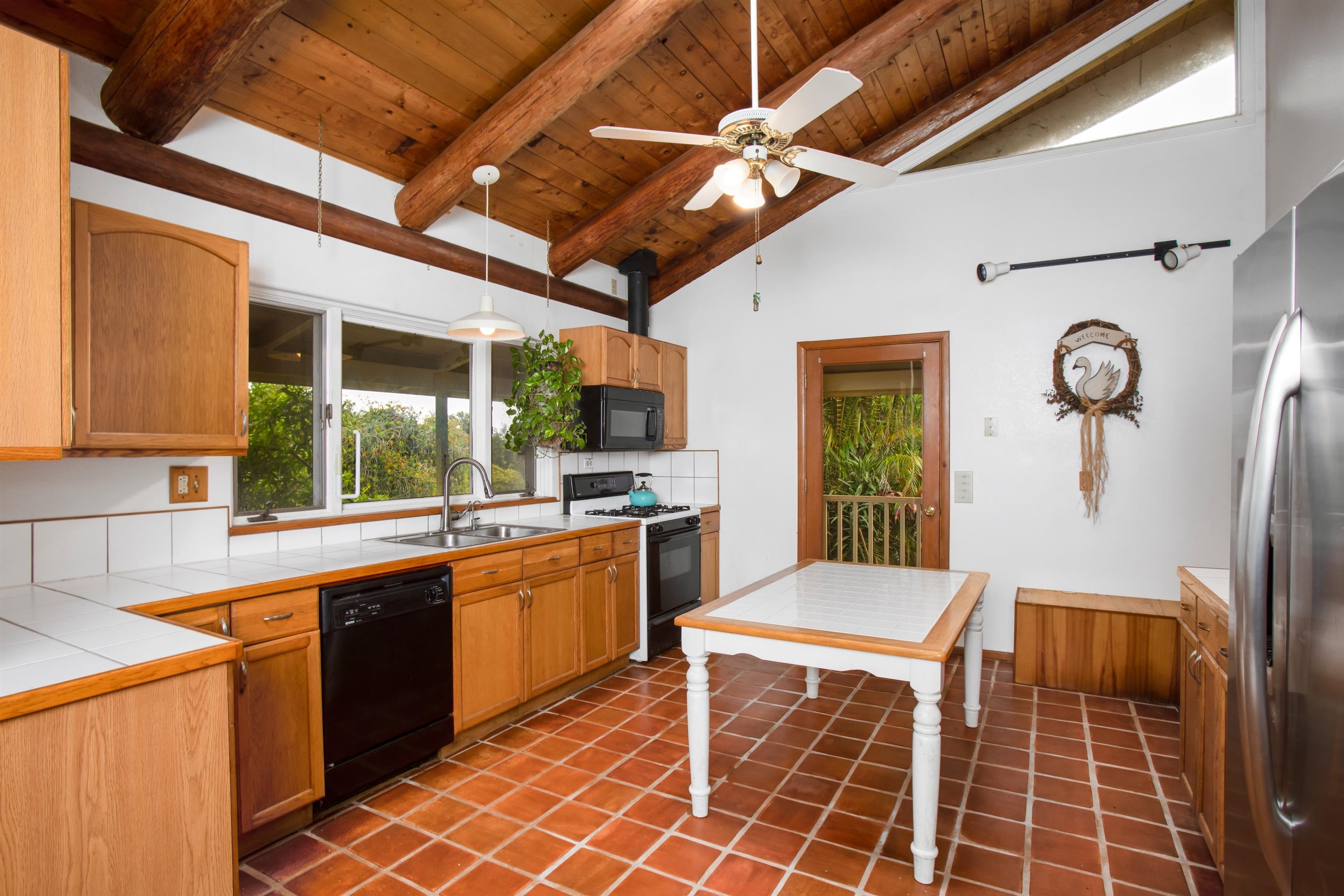 1160 Ehu Road Makawao, HI 96768 - Photo 4 of 18 a open kitchen with stainless steel appliances granite countertop a stove a sink dishwasher and a dining table with granite countertops