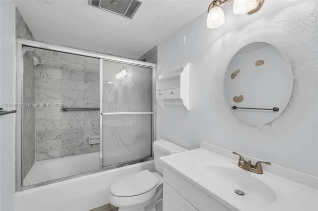 a bathroom with a sink mirror toilet and shower