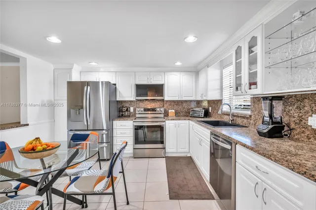 a kitchen with stainless steel appliances granite countertop a stove a sink a microwave and a refrigerator