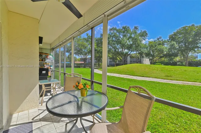 a balcony with table and chairs with wooden floor and fence