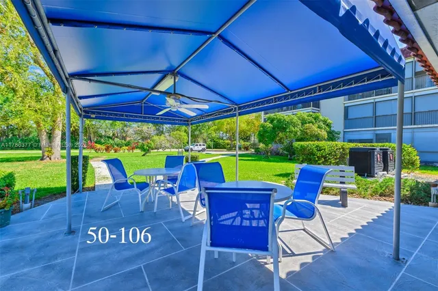 a view of a patio with table and chairs under an umbrella
