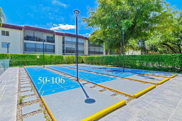a view of a tennis ground with large trees