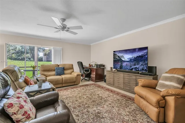 a living room with furniture ceiling fan and a rug