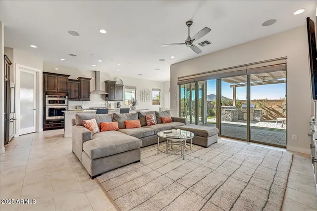 a living room with furniture a large window and stainless steel appliances