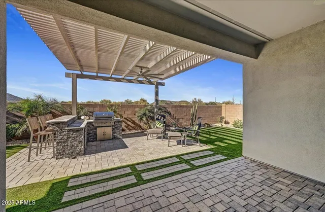 a view of a roof deck with table and chairs a barbeque with wooden floor and fence