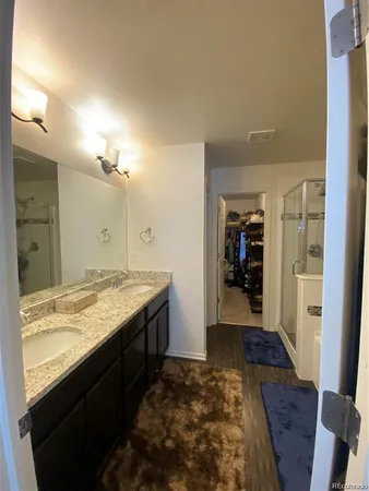 a bathroom with a granite countertop sink toilet and mirror