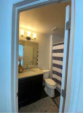 a bathroom with a granite countertop sink and a vanity