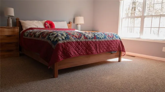 a bed sitting in a bedroom next to a window