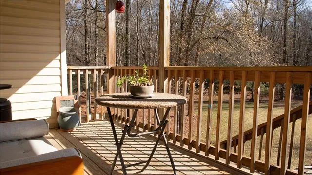 a balcony with wooden floor table and chairs