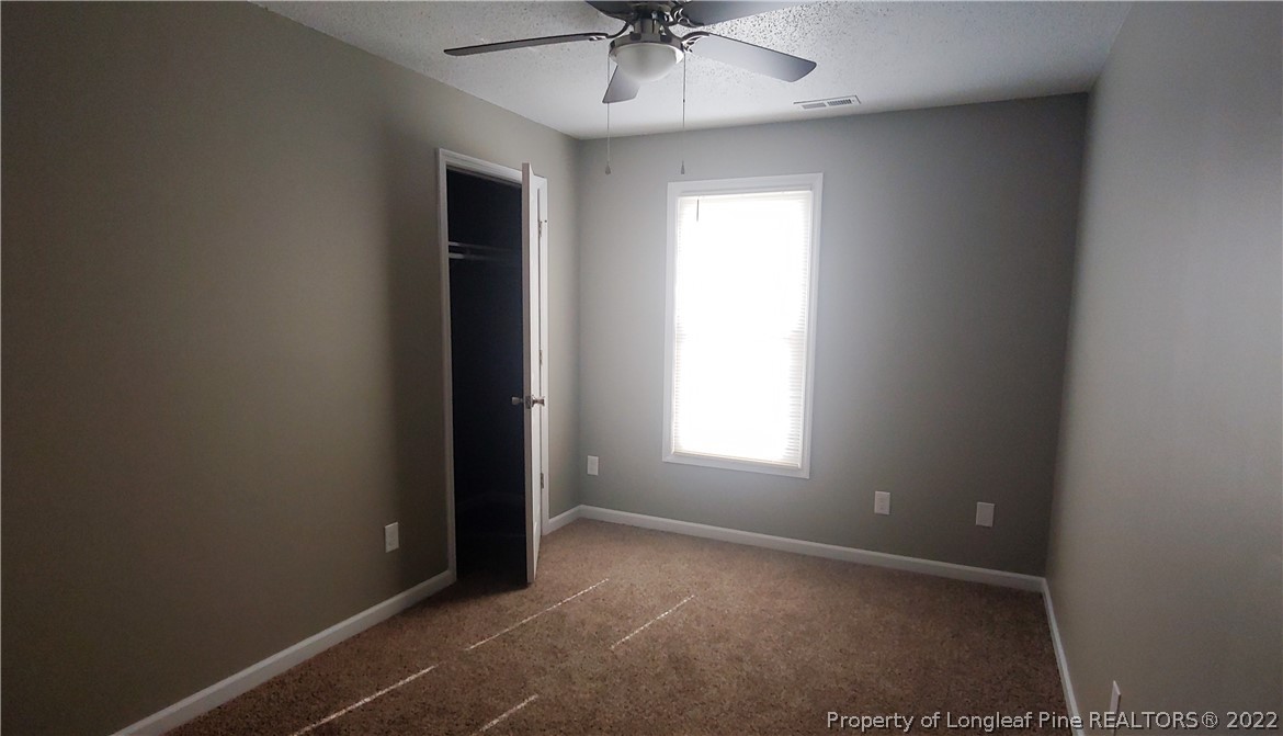 481 Camden Road Raeford, NC 28376 - Photo 11 of 18 an empty room with a ceiling fan and window