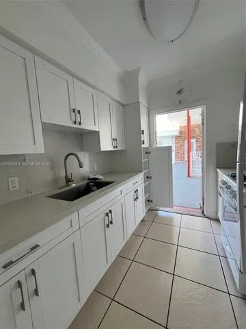 a kitchen with stainless steel appliances granite countertop a sink a stove a refrigerator and cabinets