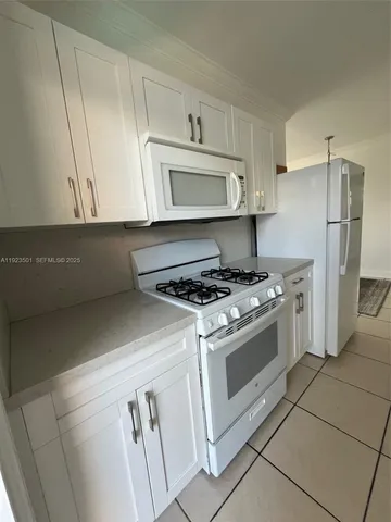 a kitchen with a stove cabinets and a refrigerator