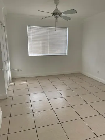 an empty room with a ceiling fan and glass door