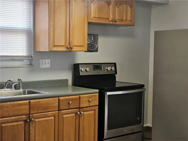 a kitchen with a refrigerator sink and cabinets