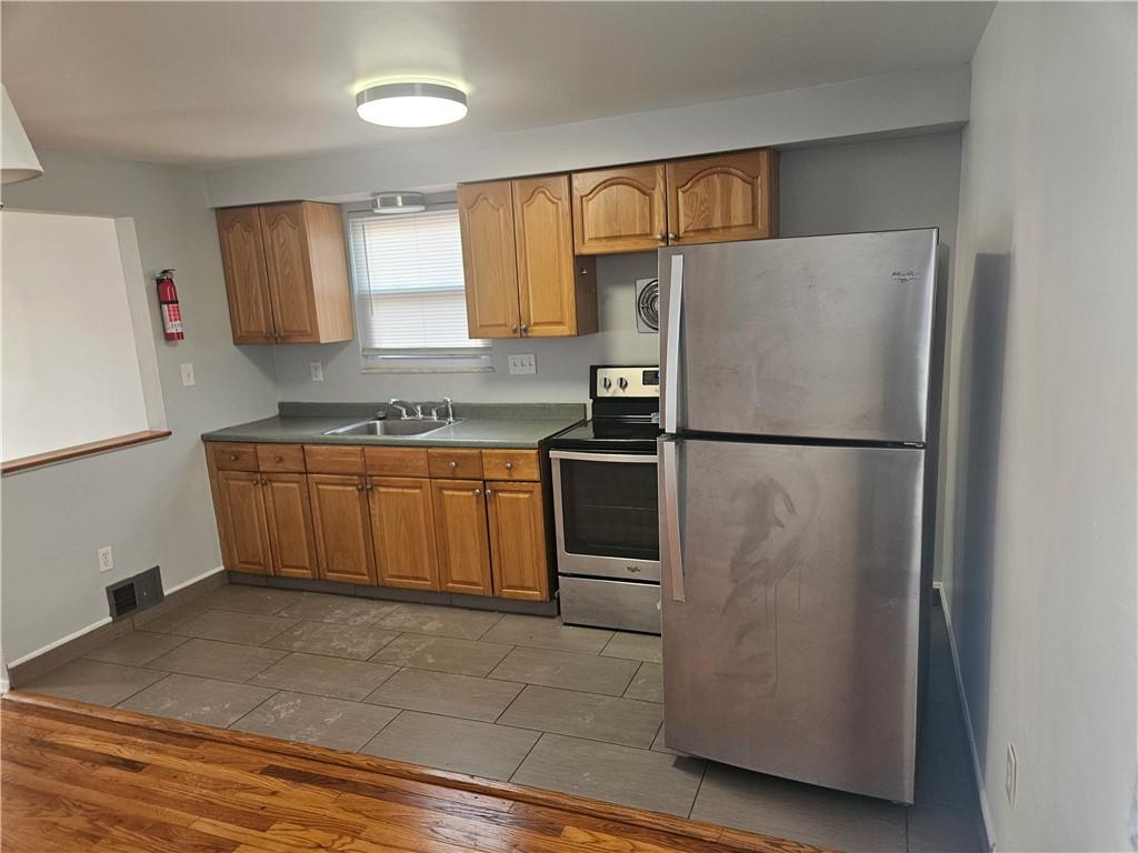 812 Westbury Road, Unit A North Versailles, PA 15137 - Photo 14 of 40 a kitchen with a refrigerator sink and cabinets