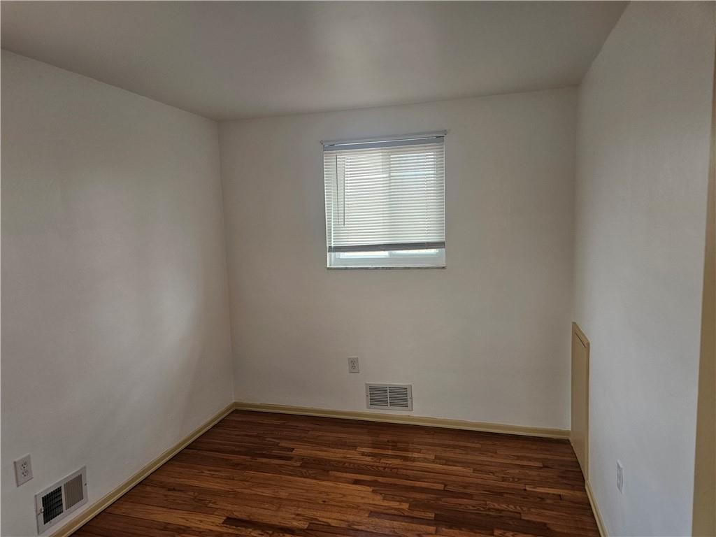 812 Westbury Road, Unit A North Versailles, PA 15137 - Photo 22 of 40 a view of an empty room with wooden floor and a window