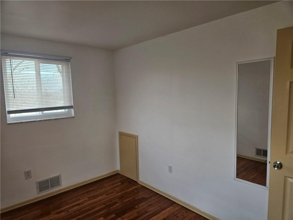 812 Westbury Road, Unit A North Versailles, PA 15137 - Photo 25 of 40 a view of an empty room with wooden floor and a window
