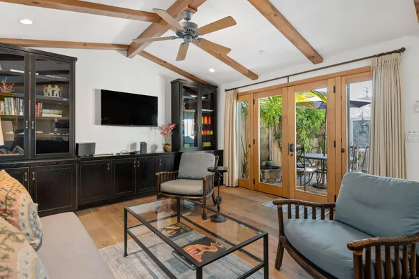 a living room with furniture a flat screen tv and a floor to ceiling window