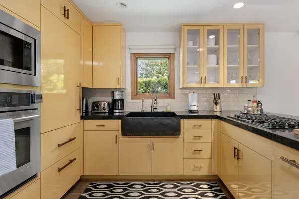a kitchen with stainless steel appliances a stove a sink and a microwave