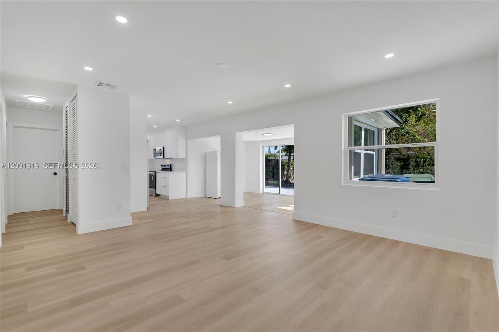 7970 Northwest 176th Street Hialeah, FL 33015 - Photo 12 of 32 a view of empty room with wooden floor and windows