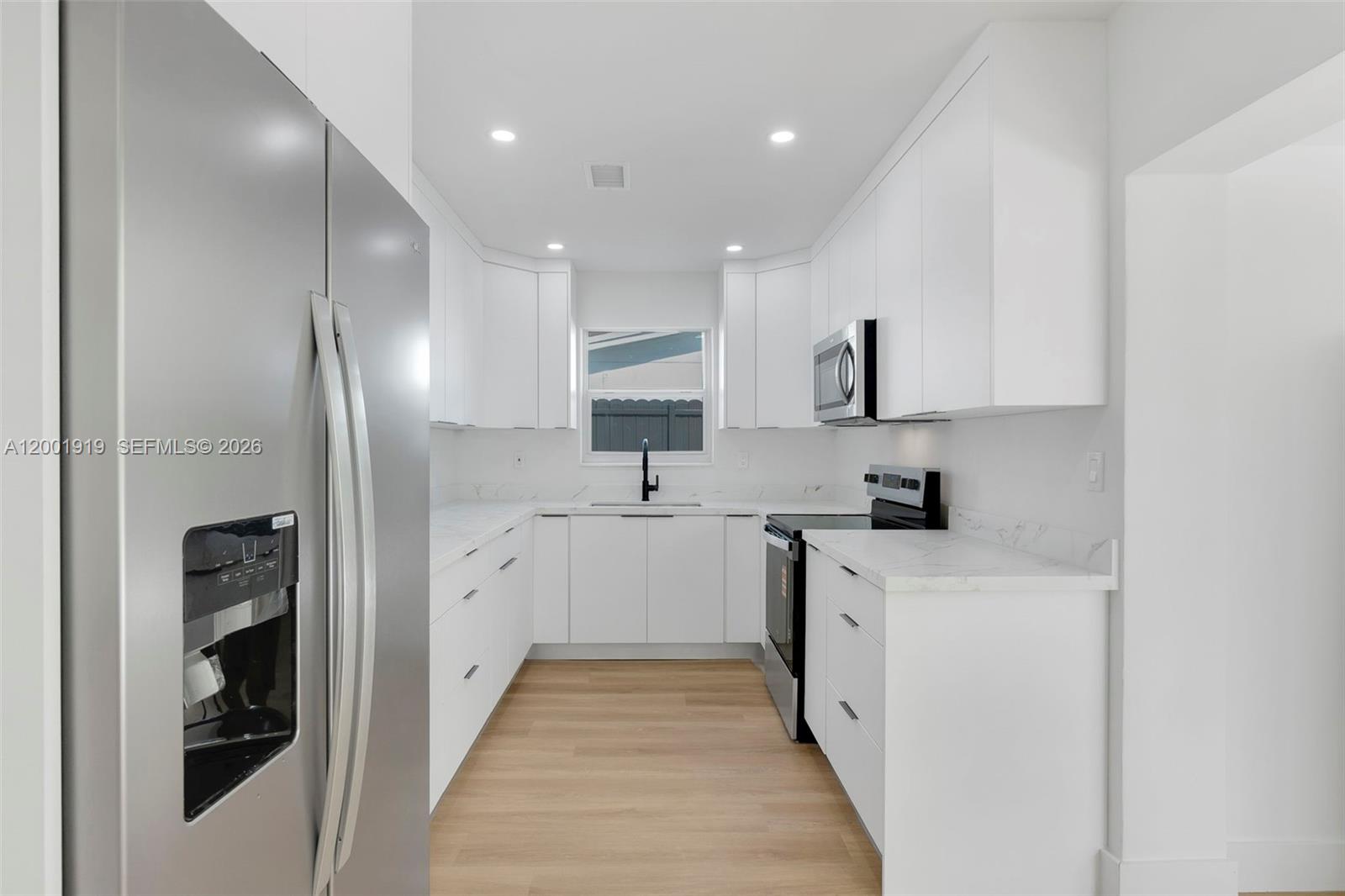 7970 Northwest 176th Street Hialeah, FL 33015 - Photo 5 of 32 a kitchen with a sink refrigerator and cabinets