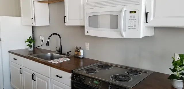 a kitchen with sink a stove and cabinets