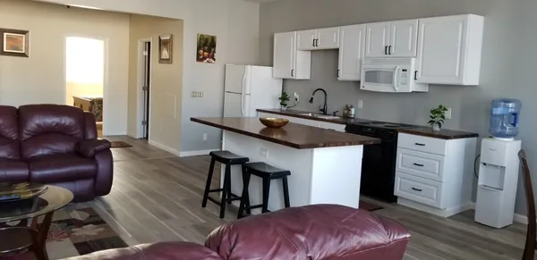 a kitchen with stainless steel appliances granite countertop a refrigerator a stove a sink and white cabinets