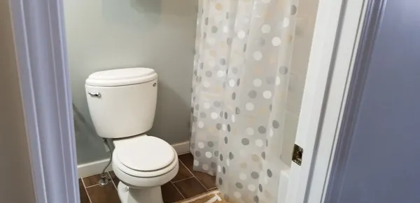 a white toilet sitting next to a shower