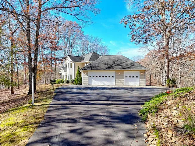 a front view of a house with a yard and fountain in middle