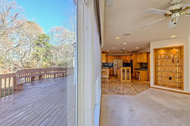 a view of a dining room and livingroom with furniture wooden floor a rug a fireplace and a chandelier