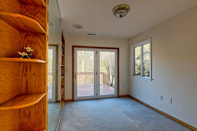 an empty room with windows and fan