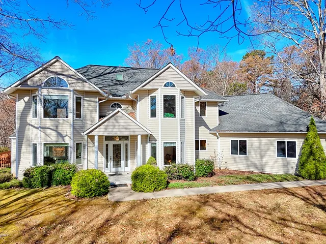 a view of a livingroom with staircase and kitchen view
