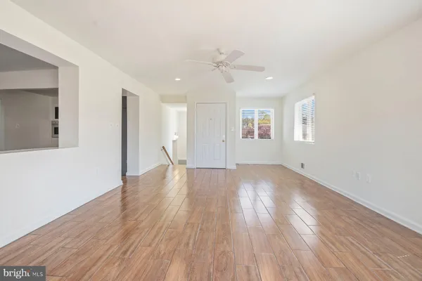a view of an empty room with window and wooden floor