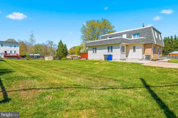 a view of a house with a big yard and palm trees