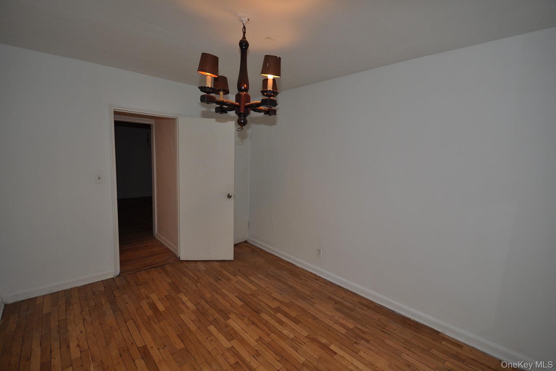 142 Garth Road, Unit 1R Scarsdale, NY 10583 - Photo 7 of 12 a view of a room with wooden floor and a ceiling fan