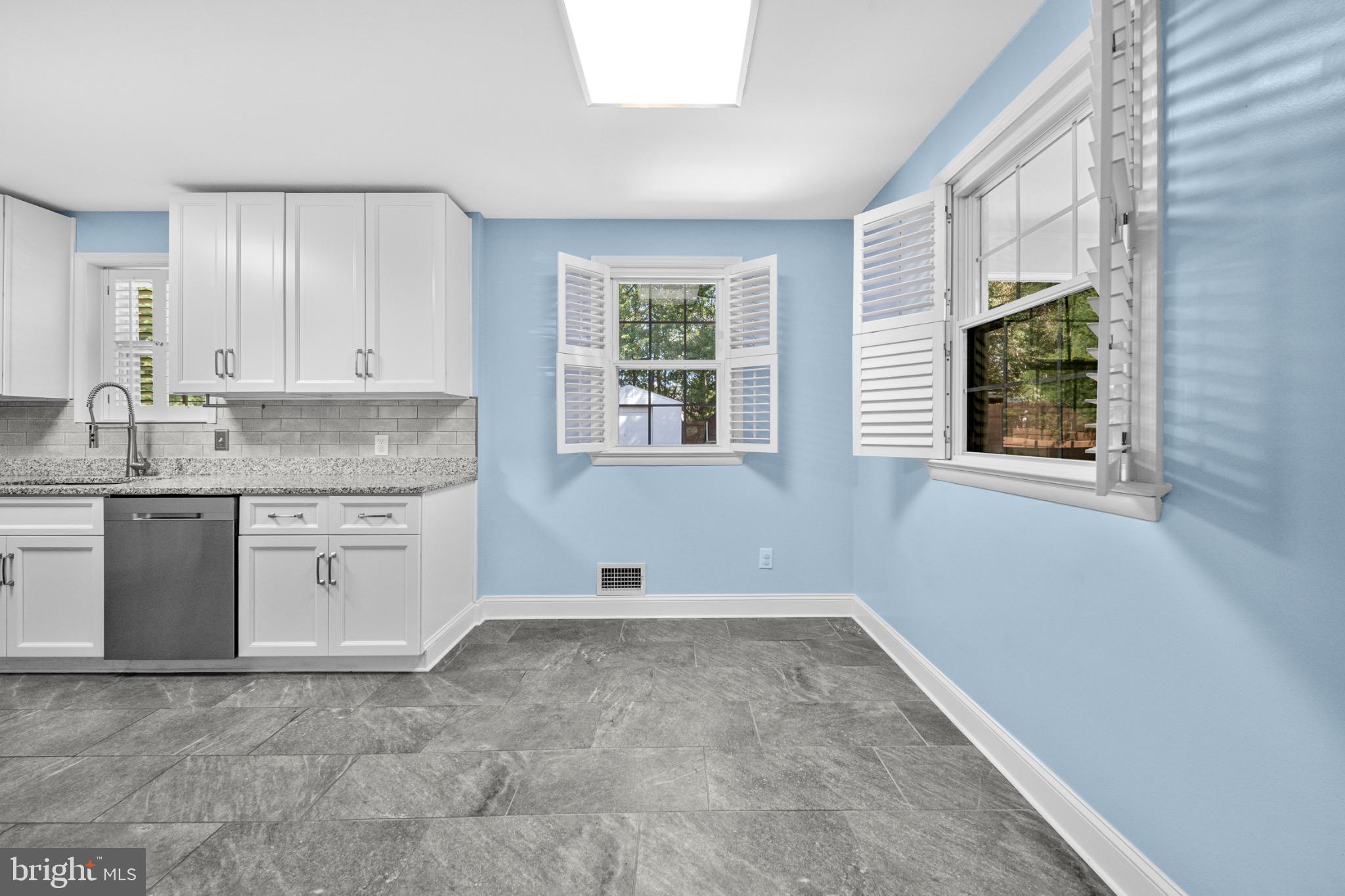 16508 Rolling Tree Road Accokeek, MD 20607 - Photo 11 of 62 a kitchen with granite countertop a stove a sink and a microwave
