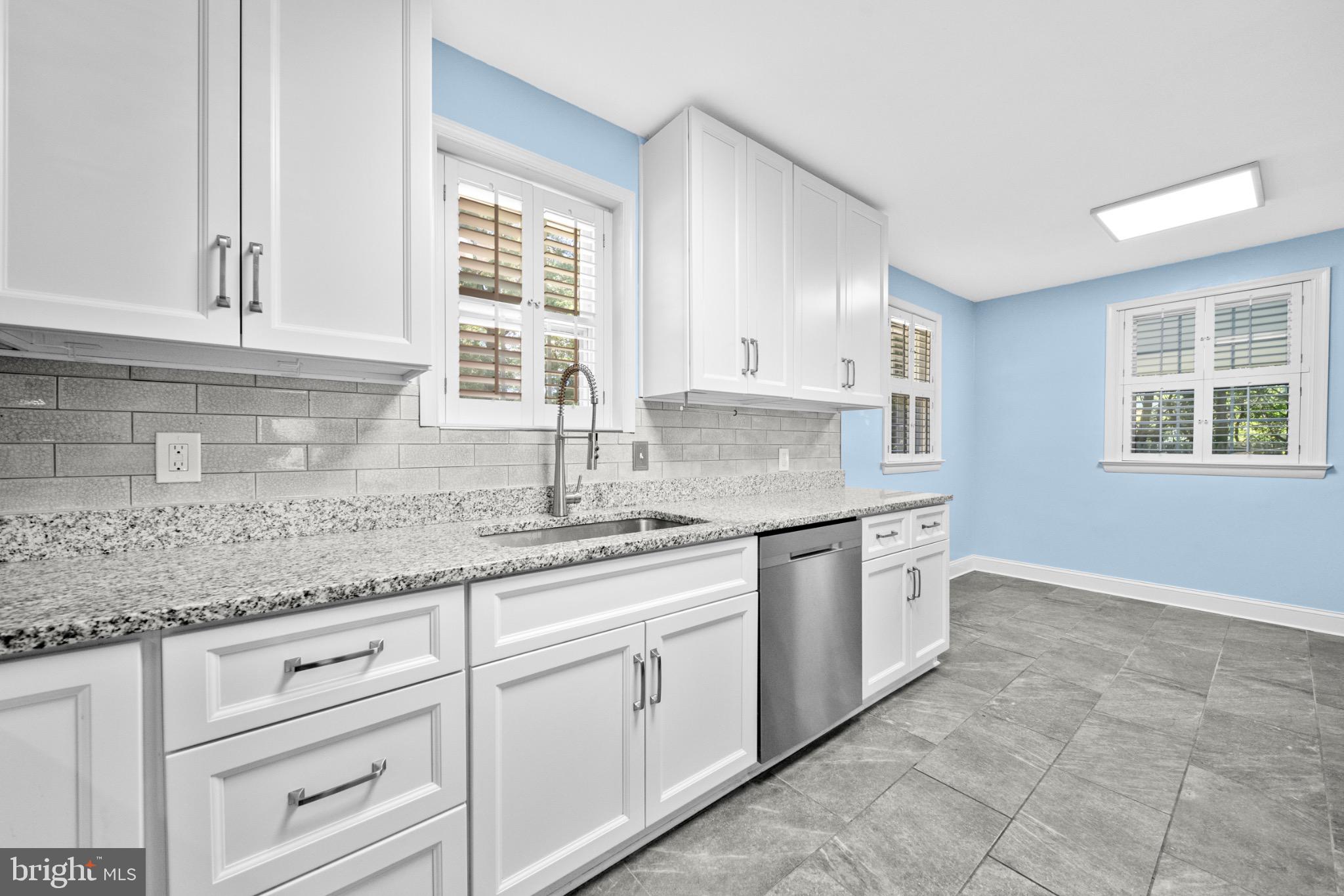 16508 Rolling Tree Road Accokeek, MD 20607 - Photo 12 of 62 a kitchen with granite countertop white cabinets stainless steel appliances a sink and a window