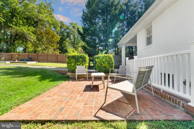 a front view of a house with a garden and trees