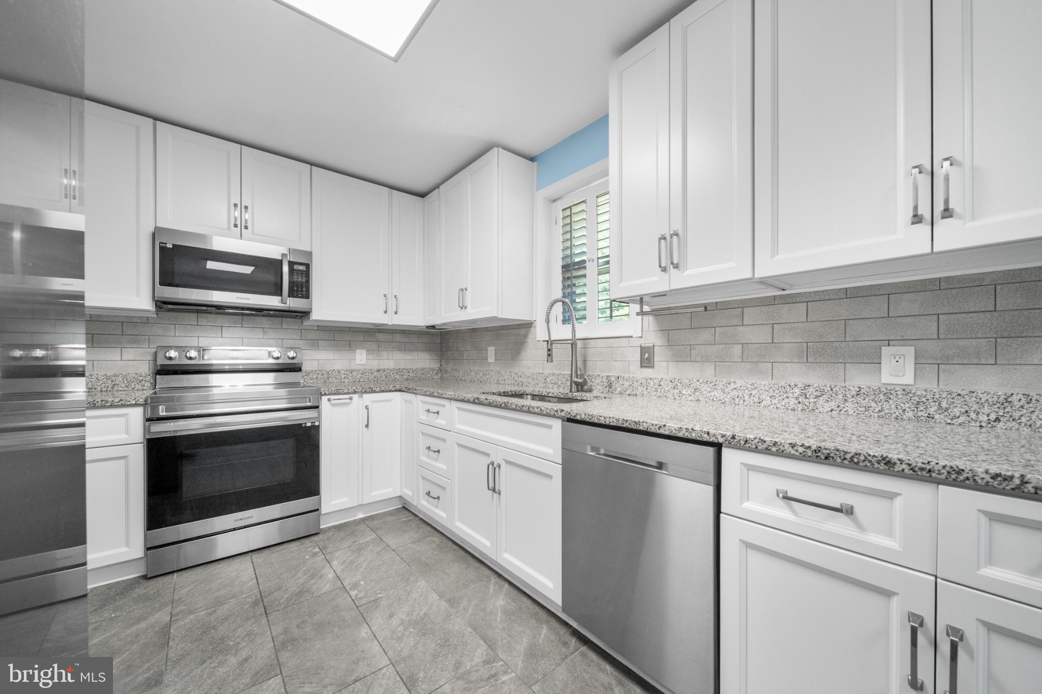 16508 Rolling Tree Road Accokeek, MD 20607 - Photo 6 of 62 a kitchen with granite countertop white cabinets and stainless steel appliances