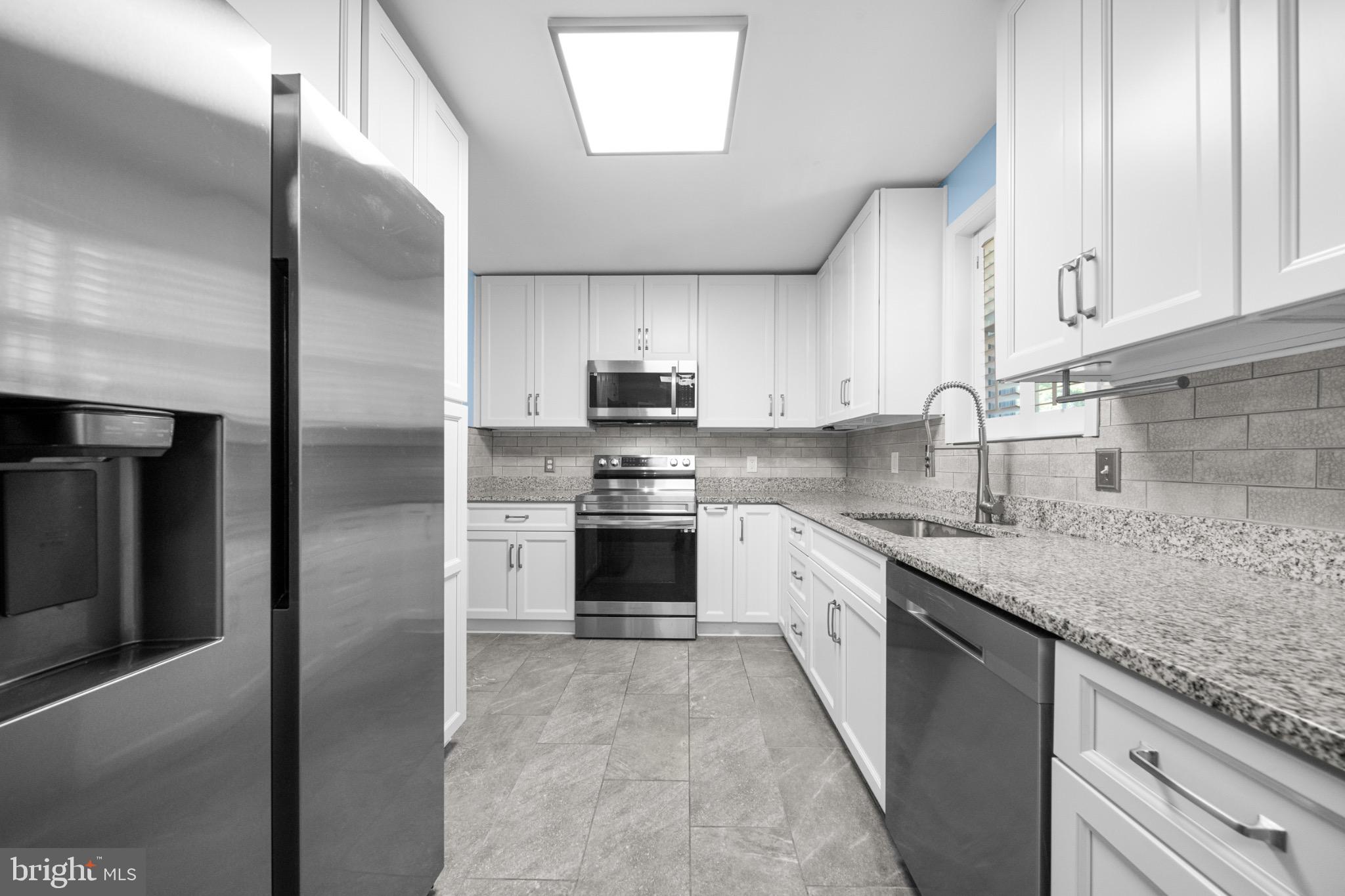 16508 Rolling Tree Road Accokeek, MD 20607 - Photo 7 of 62 a kitchen with stainless steel appliances granite countertop a refrigerator a sink a stove and oven