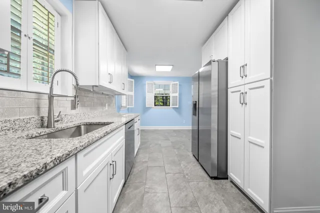 a kitchen with stainless steel appliances granite countertop a sink and a stove