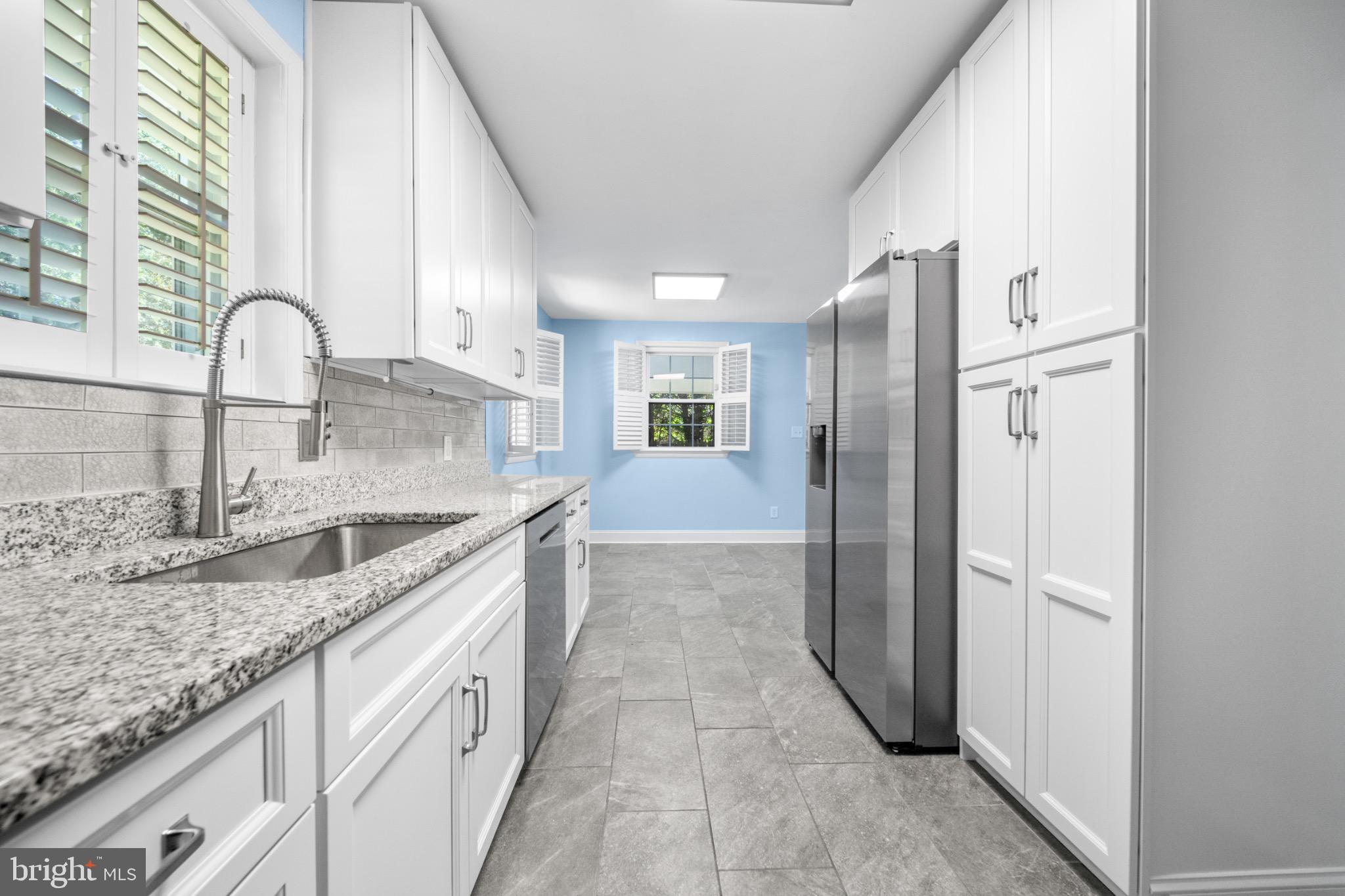 16508 Rolling Tree Road Accokeek, MD 20607 - Photo 8 of 62 a kitchen with granite countertop a sink and a refrigerator