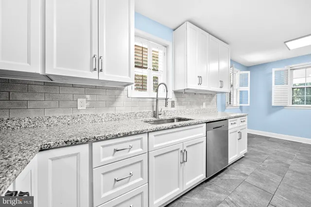 a kitchen with granite countertop a stove a sink and a microwave