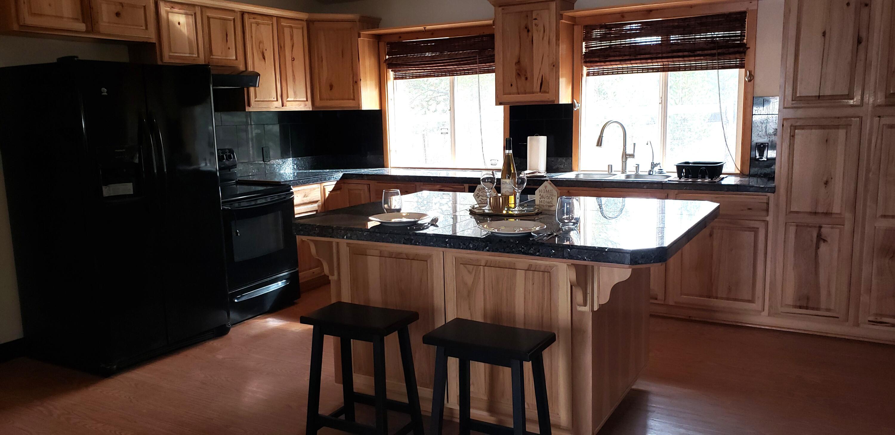 132860 Highway 97 Crescent, OR 97733 - Photo 6 of 25 a kitchen with a table chairs refrigerator and cabinets