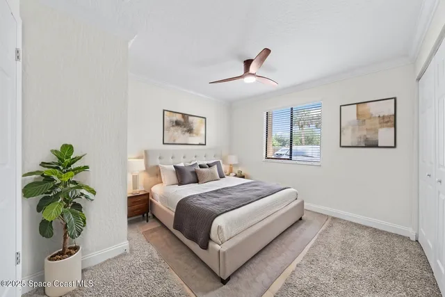 a bedroom with a bed lamp and a potted plant