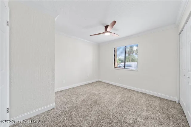 an empty room with a window and a ceiling fan