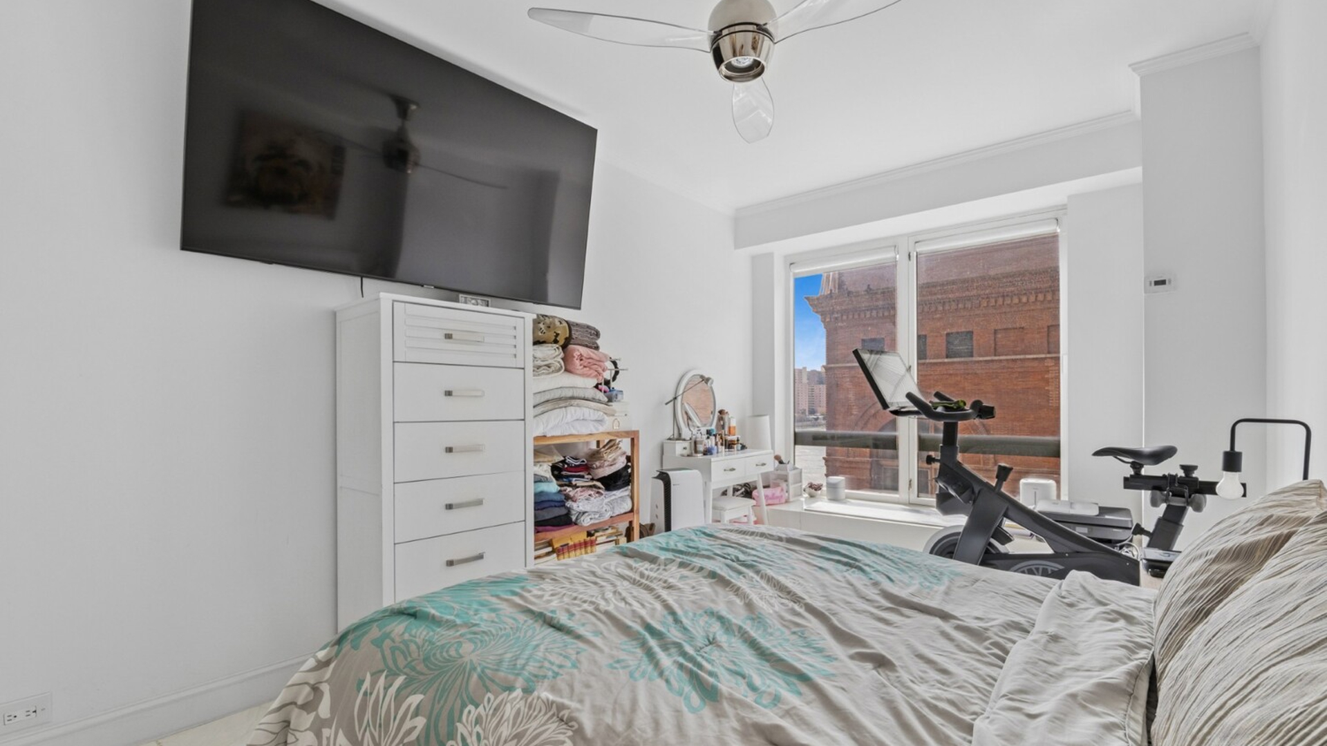 530 East 76th Street, Unit 6J Manhattan, NY 10021 - Photo 4 of 12 a bedroom with a bed and a flat tv screen