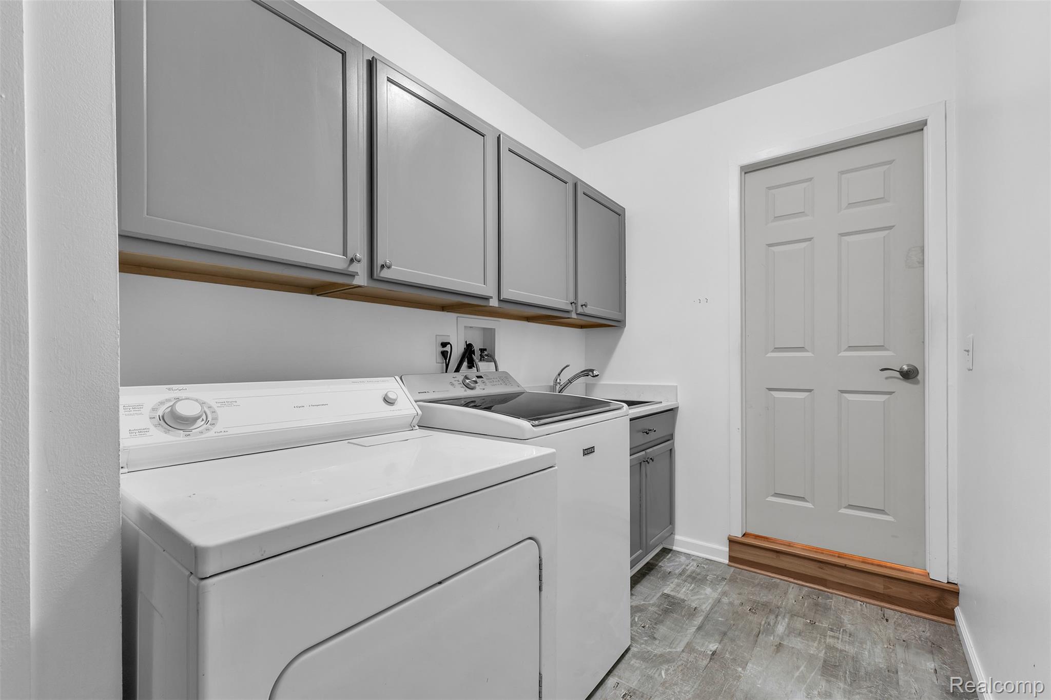 7000 Woonsocket Street Canton, MI 48187 - Photo 36 of 65 Utility room featuring gray wall cabinetry, a wood-finish shelf, a utility sink with a countertop, and wood-look flooring