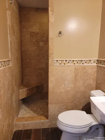a bathroom with a toilet and a shower