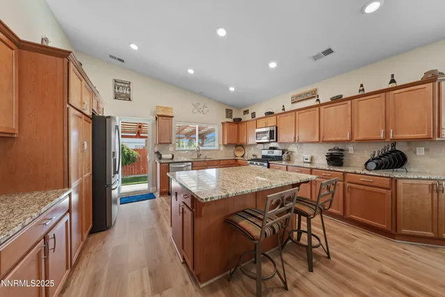 a kitchen with stainless steel appliances granite countertop a sink stove and refrigerator